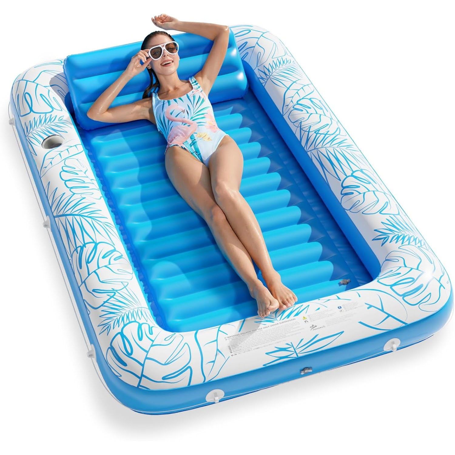 An inflatable pool float with a blue and white tropical leaf design, featuring a reclining woman in a swimsuit and sunglasses.