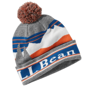 The L.L. Bean Katahdin Pom Hat features a grey, blue, and orange mountain design with a pom on top. It has a bold \“L.L. Bean\“ logo on the cuff and is made of knit material, providing warmth and style.