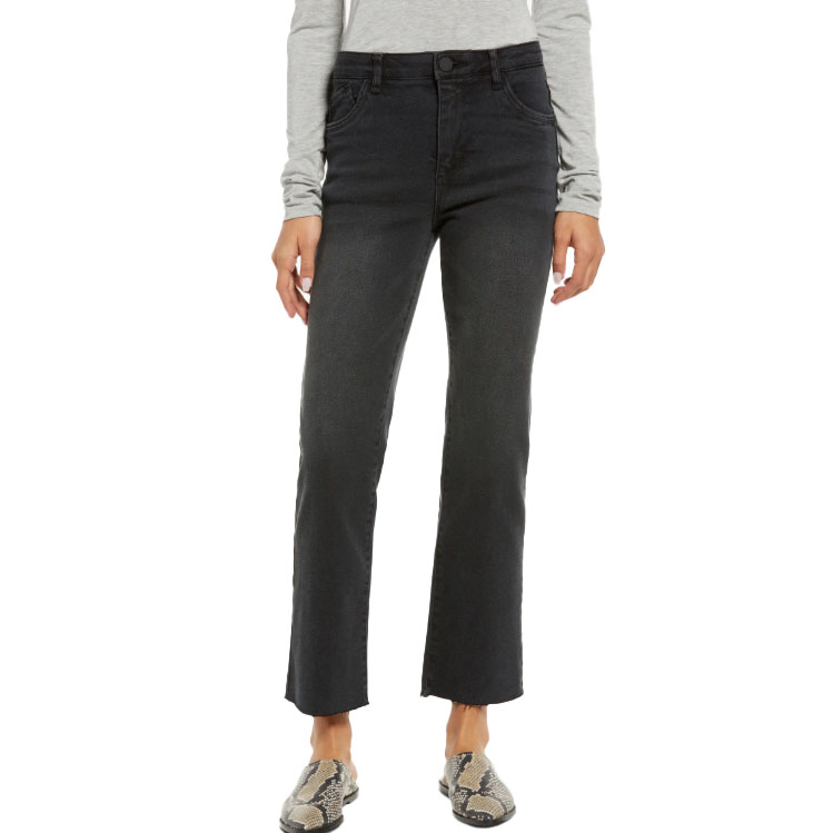 A person is wearing high-waisted, black straight-leg jeans paired with a gray long-sleeve shirt and snakeskin-patterned slip-on shoes.