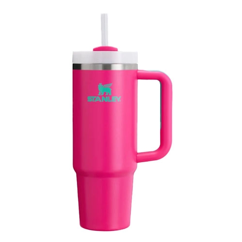 A pink Stanley tumbler with a handle and straw, featuring a stainless steel band near the lid.