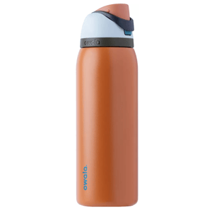 An Owala water bottle with a terracotta orange body and a blue and gray lid featuring a flip-top and carrying loop.
