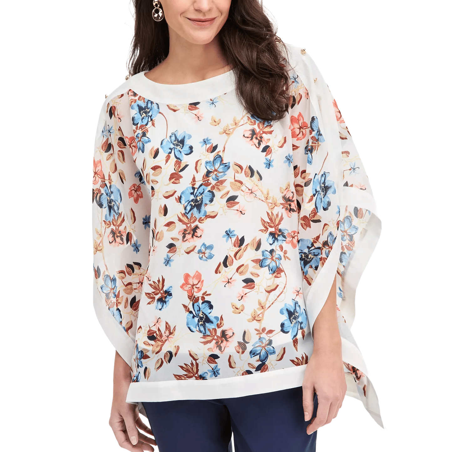A woman is wearing a sheer floral printed poncho blouse with a mix of blue, orange, and brown flowers, paired with dark pants.