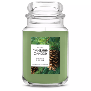 Yankee Candle in Balsam & Cedar scent, featuring a green wax in a large jar. Fragrance is described as room-filling, with imagery of pine cones and evergreen branches.