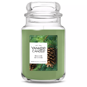 Yankee Candle in Balsam & Cedar scent, featuring a green wax in a large jar. Fragrance is described as room-filling, with imagery of pine cones and evergreen branches.