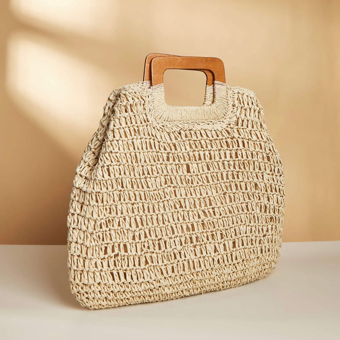 A woven tote bag with wooden top handles.