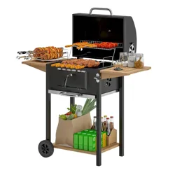 A charcoal grill with skewers, a side shelf holding jars, and storage space below containing groceries and beverages in bags and boxes.