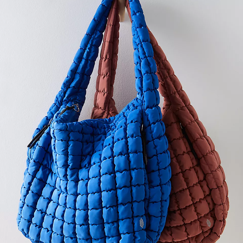 Two quilted shoulder bags, one blue and one brown.
