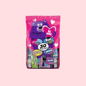 Pink package featuring a purple bear with \“Be Mine\“ text, containing 30 pieces of various candies: Sweetarts, Tootsie Taffy, Trolli Sour Bites, and Nerds.