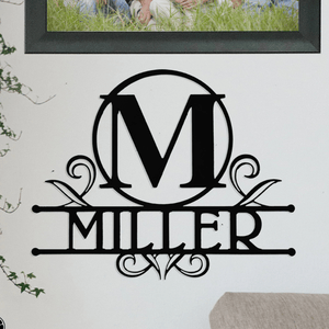 A wall decoration features a black monogram design with the letter \“M\“ in a circle and the word \“Miller\“ beneath, adorned with decorative swirls.