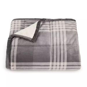 A gray plaid blanket with a sherpa lining is shown, folded with the corner turned up to reveal its soft interior.
