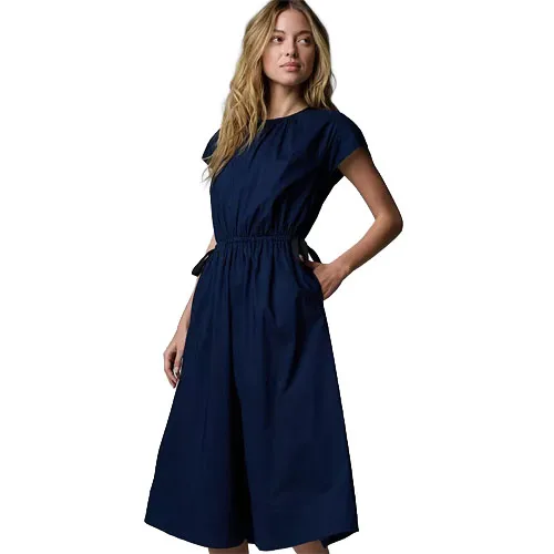 A woman wears a navy blue midi dress with short sleeves and a gathered waist.