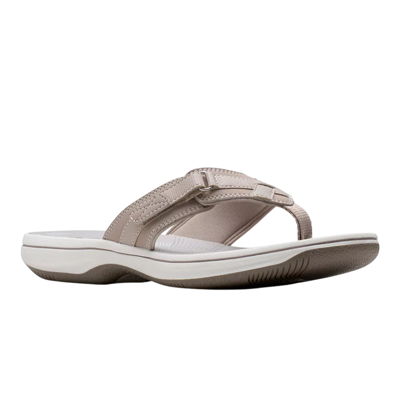 A beige flip-flop sandal with a cushioned sole and textured grip, featuring adjustable straps with stitching details.
