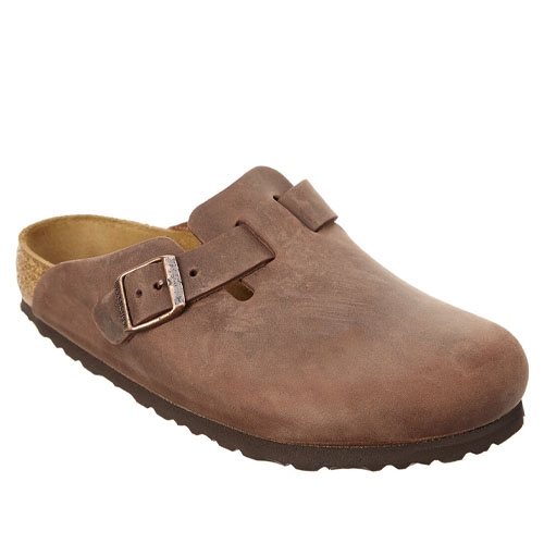 A brown leather clog featuring a buckle strap, cork footbed, and textured rubber sole.
