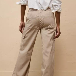 Khaki cargo pants with side pockets paired with a white blouse.