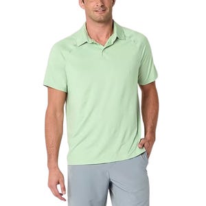 Light green short-sleeve polo shirt made from cooling, moisture-wicking fabric, featuring a classic collar and button closure, paired with gray pants.