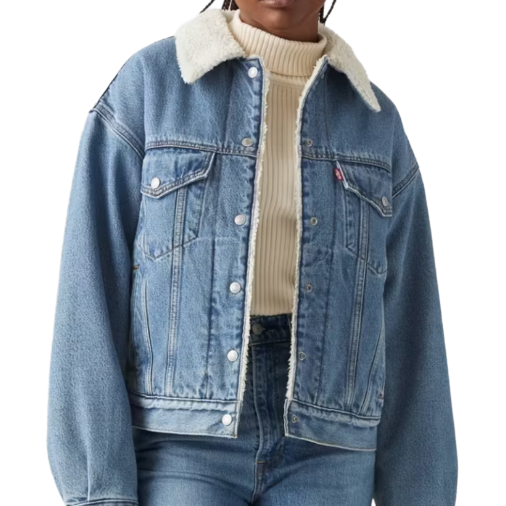 A blue denim jacket with a white shearling collar, button-up front, and front pockets, worn over a cream ribbed turtleneck sweater.