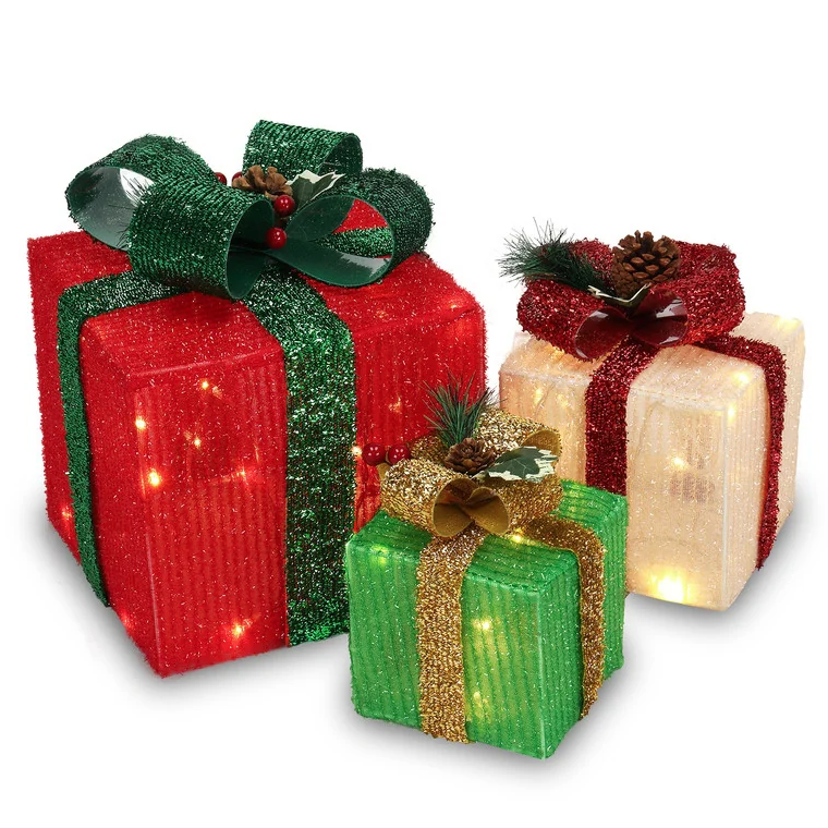 Three decorative gift boxes with glittery ribbons in red, green, and gold, adorned with pinecones and holly. The boxes are lit from within, creating a festive appearance.