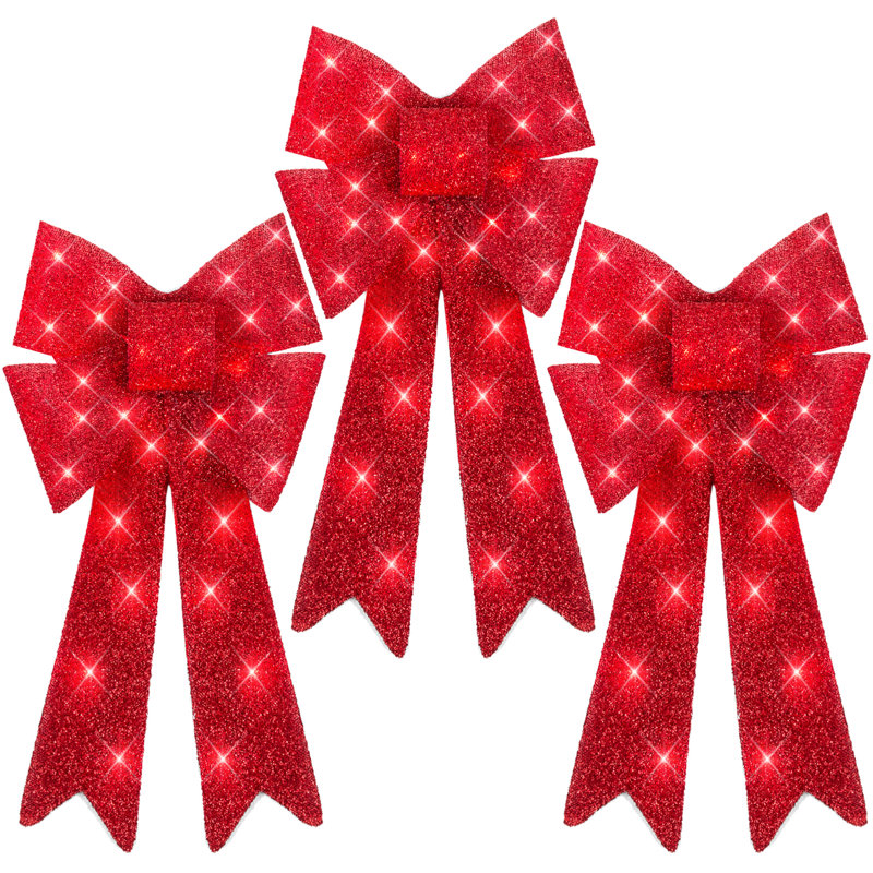 Three red glittery holiday bows with long tails and sparkling accents.