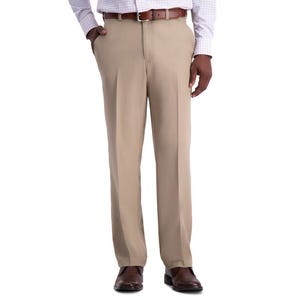 A person wearing beige dress pants with a brown belt, checkered dress shirt, and brown shoes.