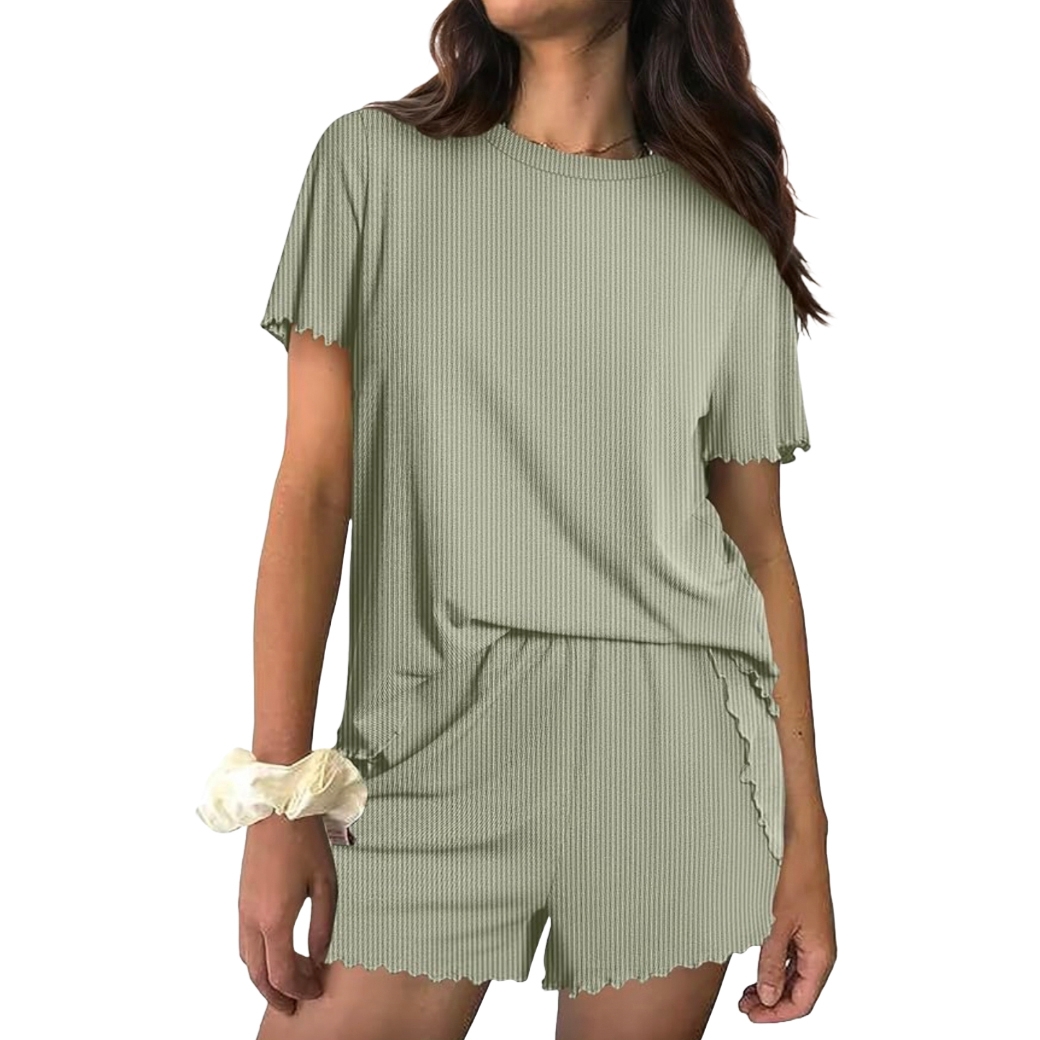 A woman wearing a light green, short-sleeve, ribbed lounge set with matching shorts. She has a light-colored scrunchie on her wrist.