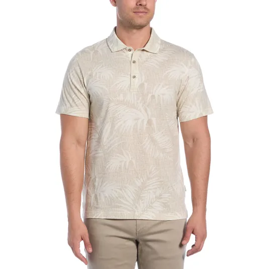 A light beige polo shirt with a tonal palm tree pattern, short sleeves, and a buttoned collar, paired with beige pants.