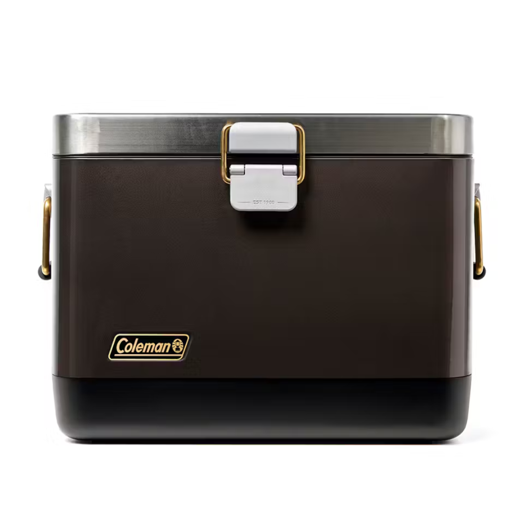 Coleman 20-Qt. Steel Belted Cooler features a vintage design with a brown exterior, stainless steel accents, gold-tone handles, and a sturdy latch. It's designed for durability and insulation, suitable for keeping items cool during outings.
