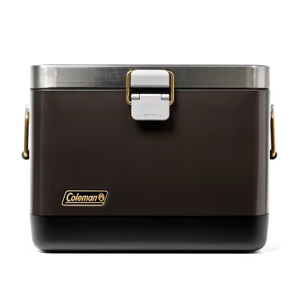Coleman 20-Qt. Steel Belted Cooler features a vintage design with a brown exterior, stainless steel accents, gold-tone handles, and a sturdy latch. It's designed for durability and insulation, suitable for keeping items cool during outings.