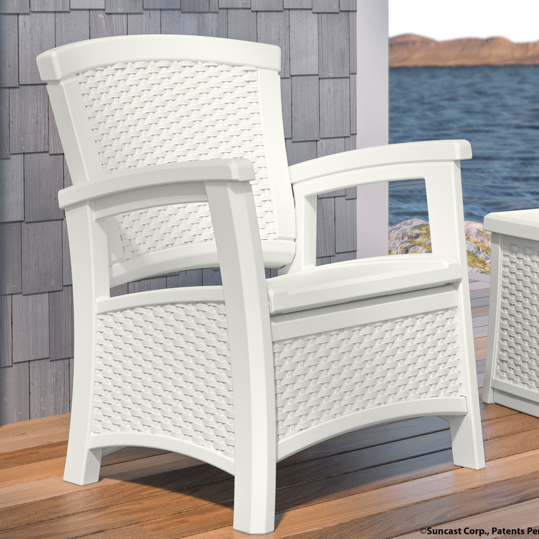 White chair with woven pattern design, featuring armrests and built-in storage under the seat. Suitable for outdoor use, placed on a wooden deck with a coastal view background.