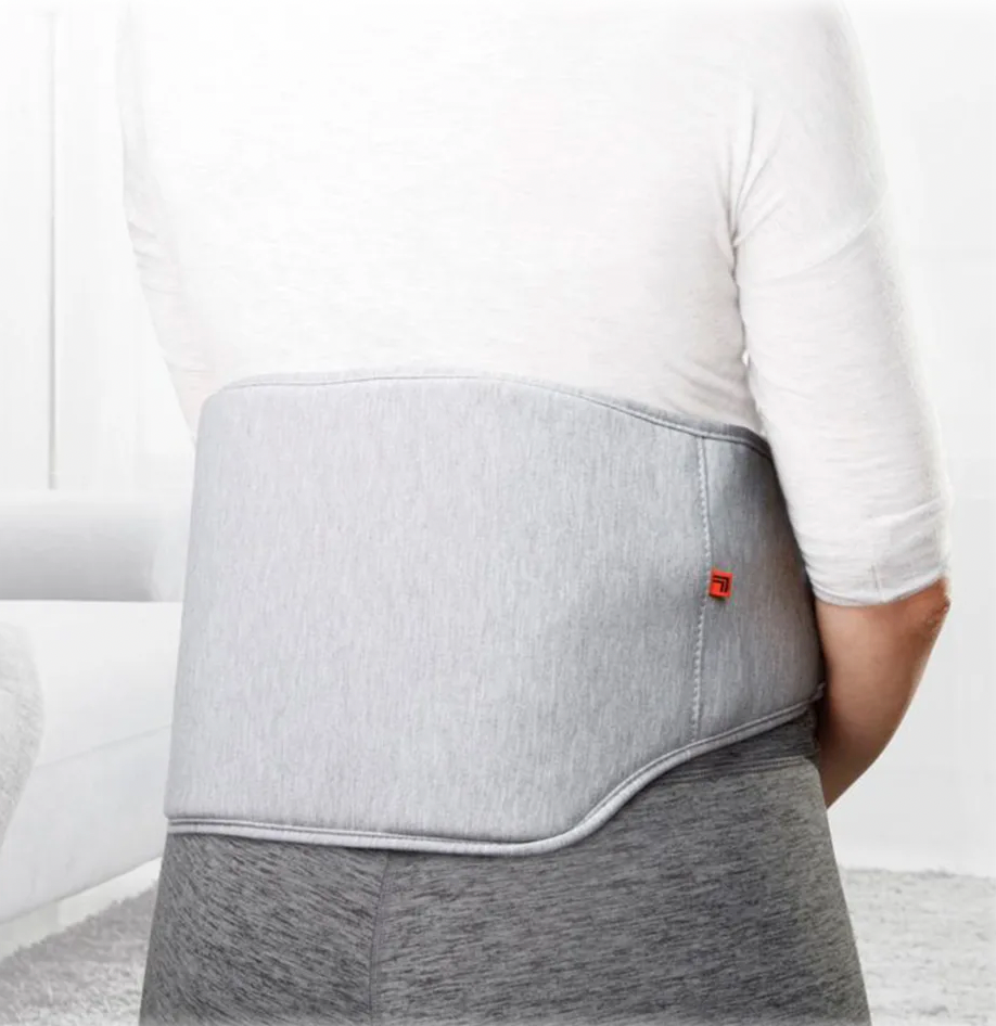 The Sharper Image Heated Back Massager is a gray wrap worn around the lower back, providing soothing heat massage to relieve tension and support comfort.
