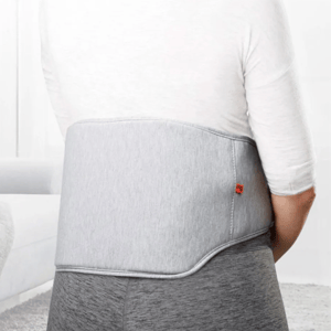 The Sharper Image Heated Back Massager is a gray wrap worn around the lower back, providing soothing heat massage to relieve tension and support comfort.