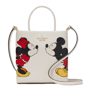 Kate Spade New York tote featuring Disney's Mickey and Minnie Mouse depicted in a kissing pose on a white background. It includes a top handle, a detachable crossbody strap, and gold-tone hardware accents.