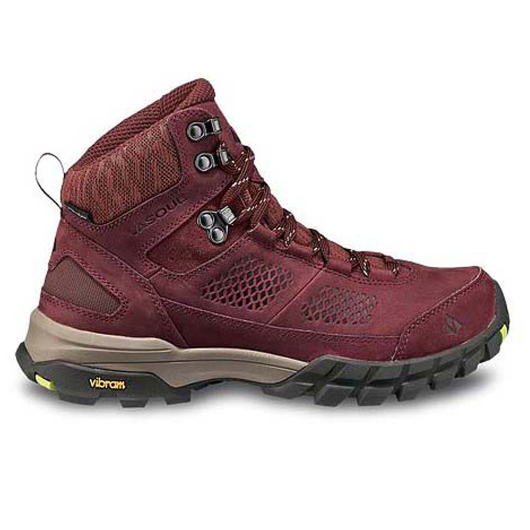 Vasque Waterproof Hiking Boots in maroon feature a durable upper, metal eyelets, a padded ankle collar, and a textured Vibram sole for traction, designed for outdoor activities.