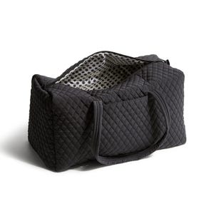A black quilted fabric cosmetic bag with a patterned interior and a zippered opening.