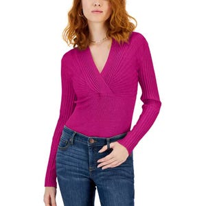 A person is wearing a pink, long-sleeve, ribbed, V-neck wrap top paired with blue jeans.