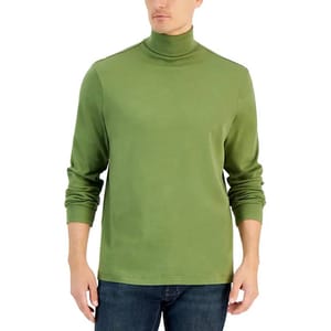 A person wearing a green turtleneck shirt with long sleeves and dark blue jeans.