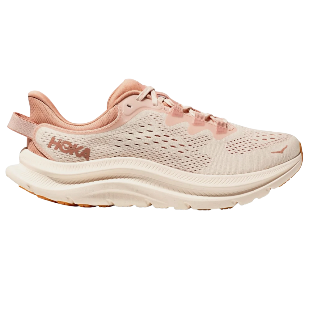 A HOKA pink and beige running shoe with a sculpted midsole, breathable perforated upper, and distinctive pull tab on the heel.
