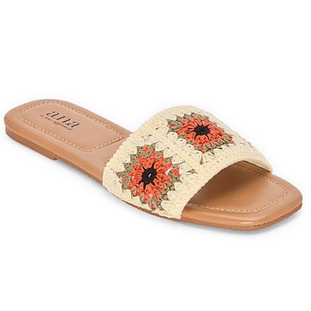 A flat slide sandal featuring a crochet strap with red and beige floral patterns, and a tan sole embossed with \“a.n.a\“ branding.