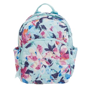 The Vera Bradley Essential Compact Backpack features a quilted design with a floral pattern in shades of blue, pink, and purple. It includes a front zippered pocket, side slip pockets, and a top handle.