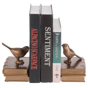 Gold bird bookends support three books: \“Al Pacino Scarface,\“ \“Sentiment,\“ and \“Sharing the Good News\“ by Casey.