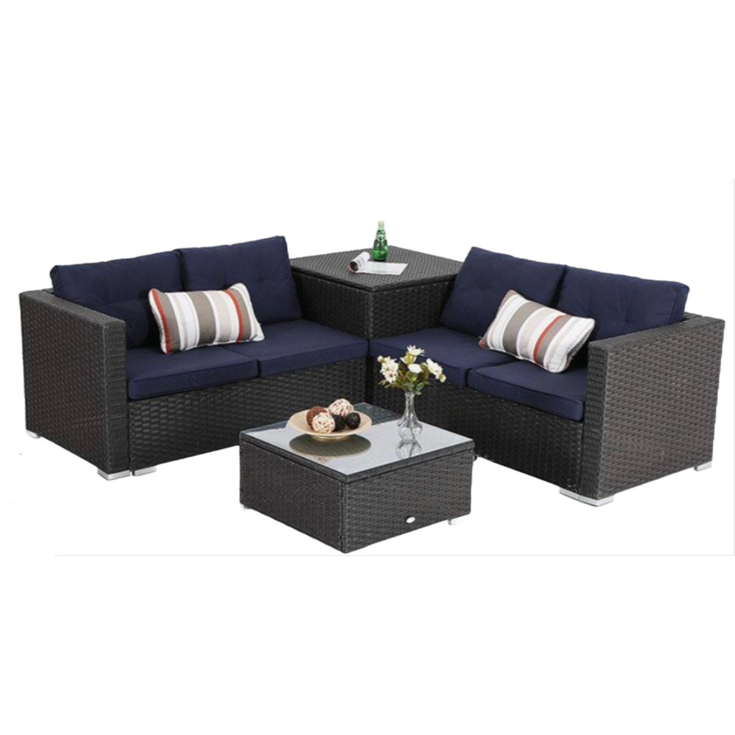 Outdoor wicker patio furniture set with navy cushions, includes a two-piece sofa with striped pillows, corner table, and a glass-top coffee table with a vase and decorative items.