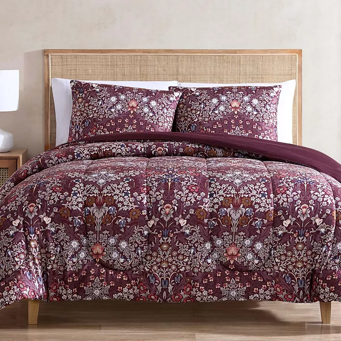 Bed with floral-patterned bedding set including a comforter and matching pillowcases.