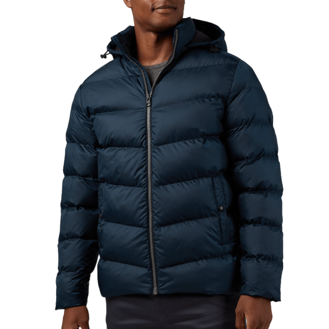 A man is wearing a navy blue, hooded puffer jacket with a front zipper, suitable for cold weather.