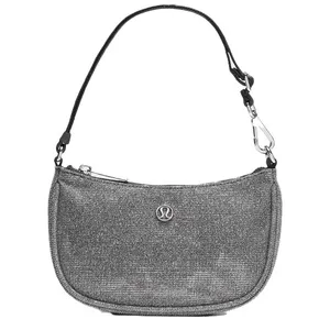 A gray shoulder bag with a zip closure and a carabiner clip on the strap, featuring a small logo on the front.