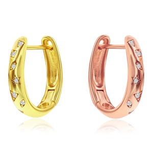 Gold and rose gold-toned sterling silver hoop earrings, each embellished with small star-shaped accents set with sparkling stones.