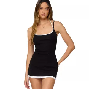 A woman wearing a form-fitting black mini dress with white trim on the straps and hem, and a matching headband.