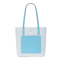 A two-tone Kate Spade tote bag with a large blue square on the front, blue handles, and the brand name at the top center.