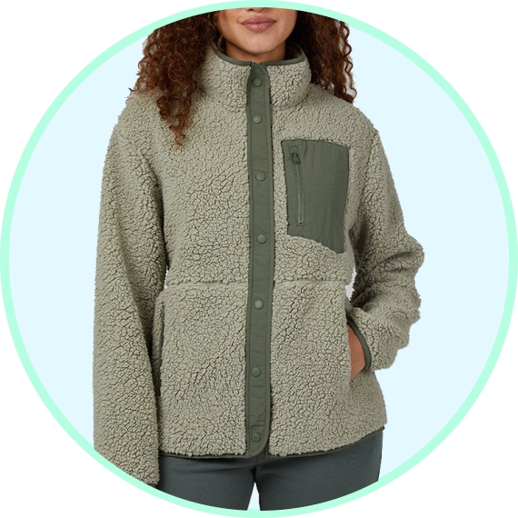 A person wearing a fleece jacket with a high neck and button-up front, featuring a contrasting chest pocket.