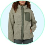 A person wearing a fleece jacket with a high neck and button-up front, featuring a contrasting chest pocket.