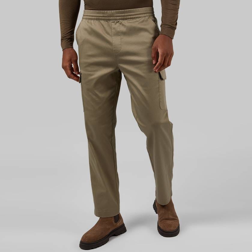 Khaki cargo pants with elastic waistband and cuffs, side cargo pockets, and visible seams, paired with brown suede shoes.