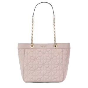 A quilted pink tote bag with chain and leather handles. The design features a subtle floral pattern, and the brand's logo is embossed near the top.